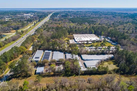 Aerial view of self storage facility in wooded area near highway access